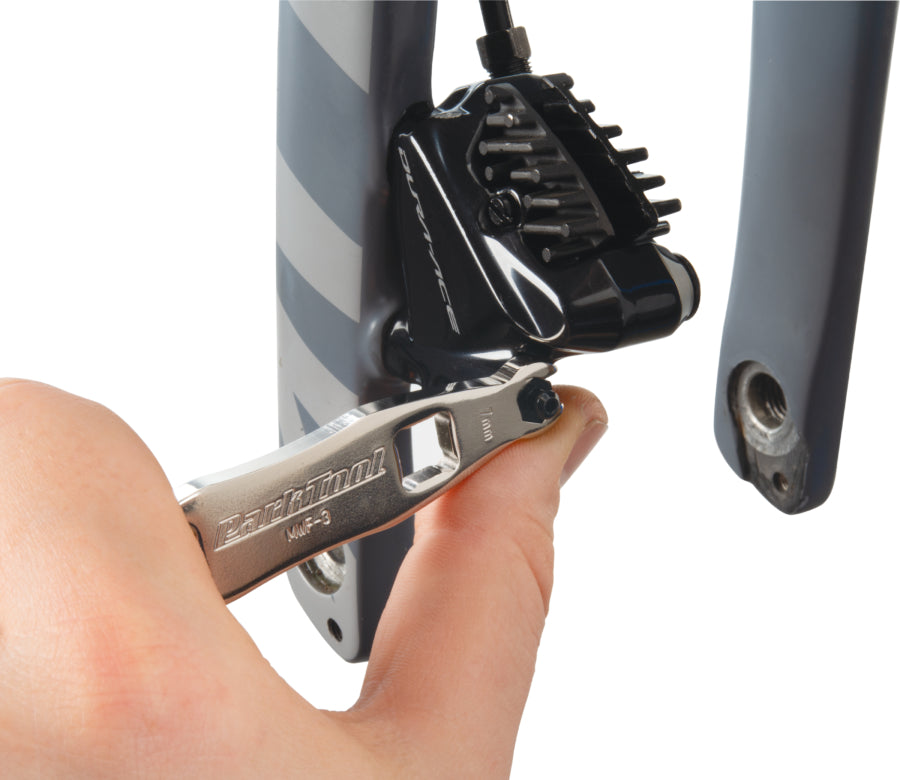 Park Tool MWF-3 serrant une purge d'étrier de frein à disque